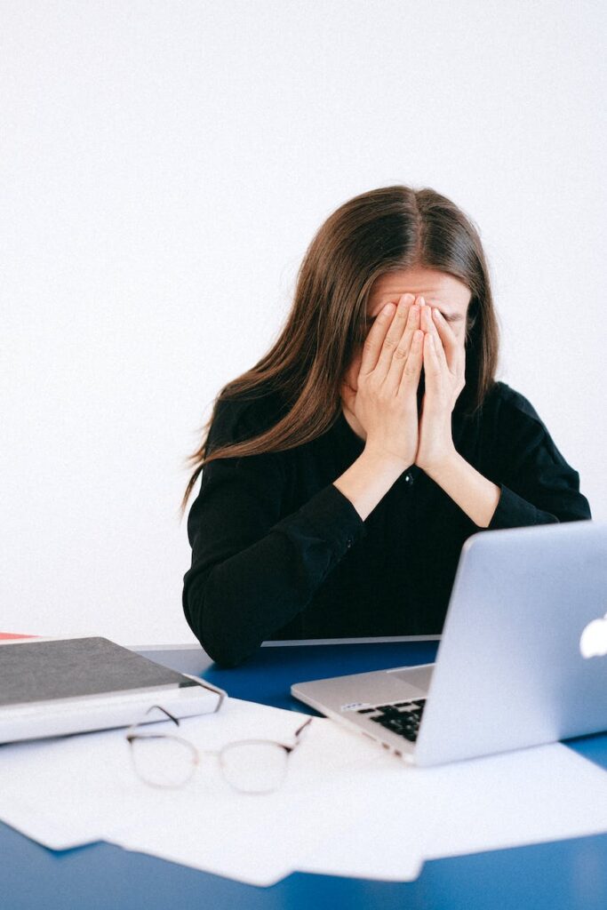 stressed woman covering her face with her hands